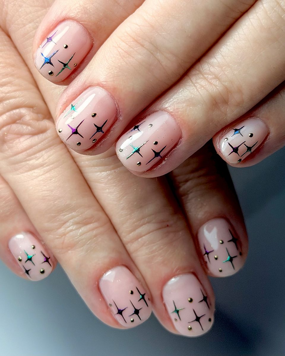Twinkling stars on a soft nude by The Nail Editor