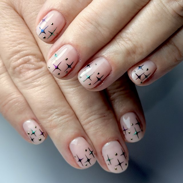 Twinkling stars on a soft nude by The Nail Editor